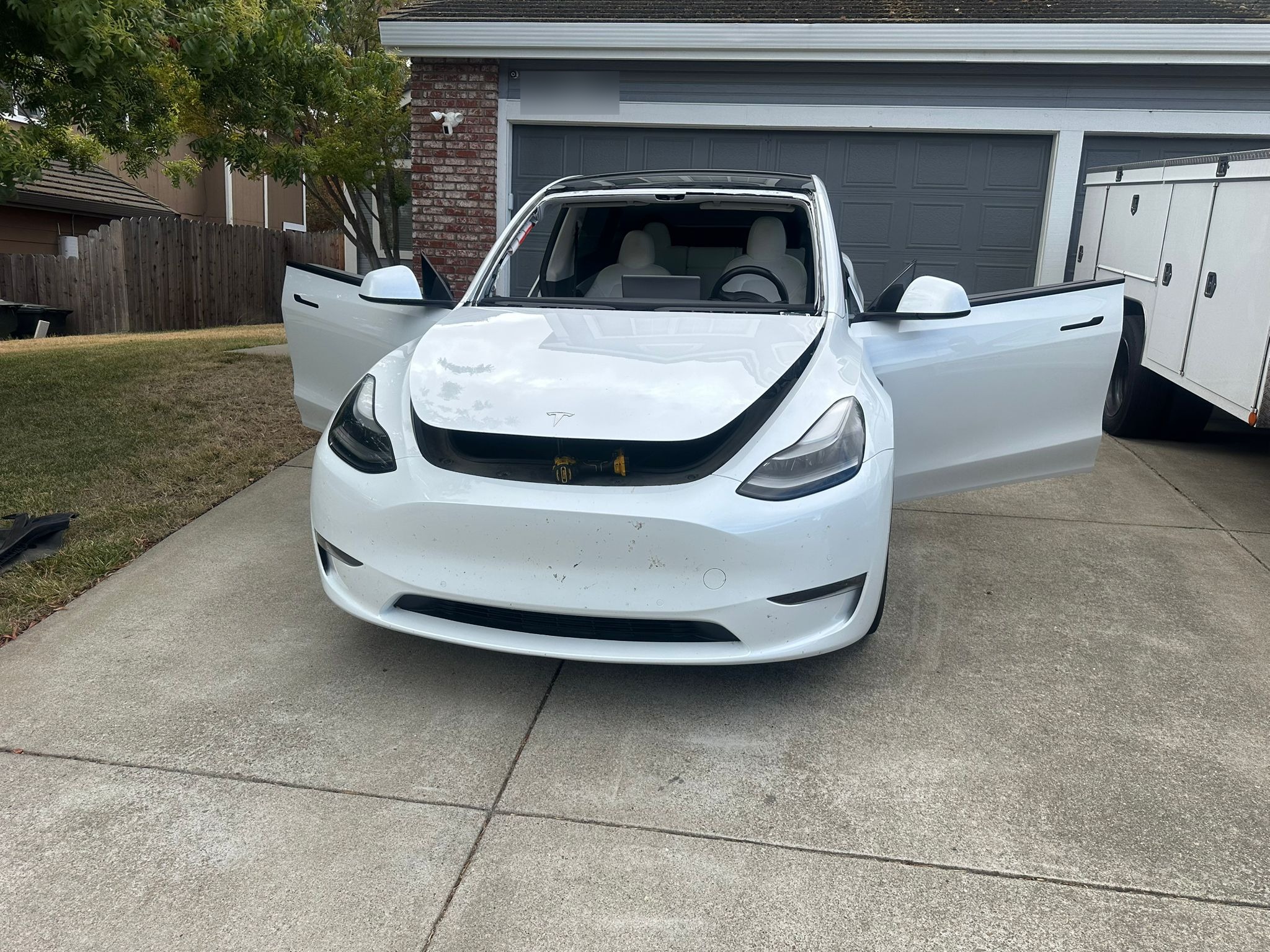White Tesla Model Y in driveway during mobile windshield replacement service by East Valley Auto Glass
